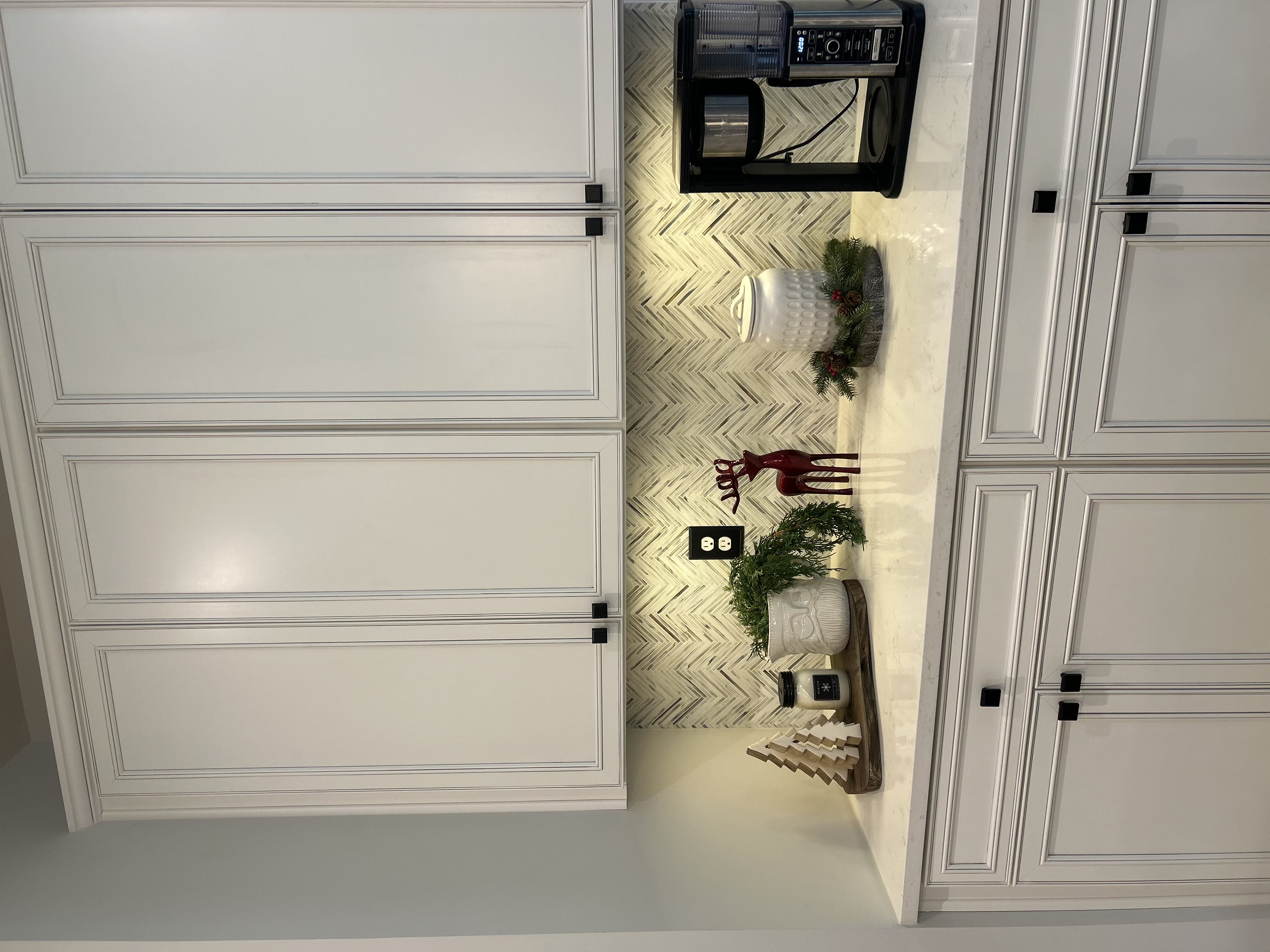 The far left side of a kitchen with a white tile backsplash